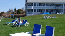 Guests relaxing in lounge chairs on the Beachmere Inn lawn.