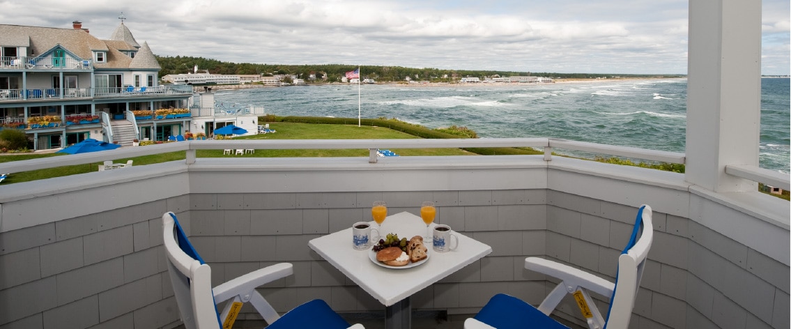 View of the lawn and coastline from second floor balcony, including table with included continental breakfast.